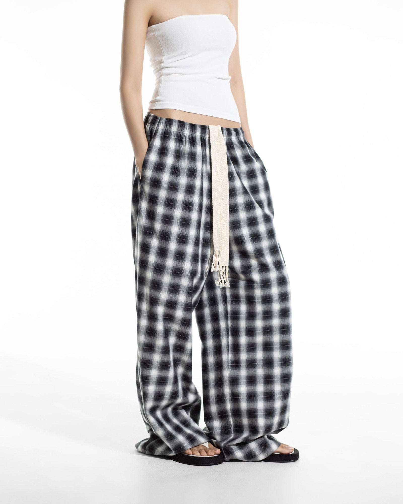 Black plaid check wide leg pants styled with a white tube top and sandals, full length