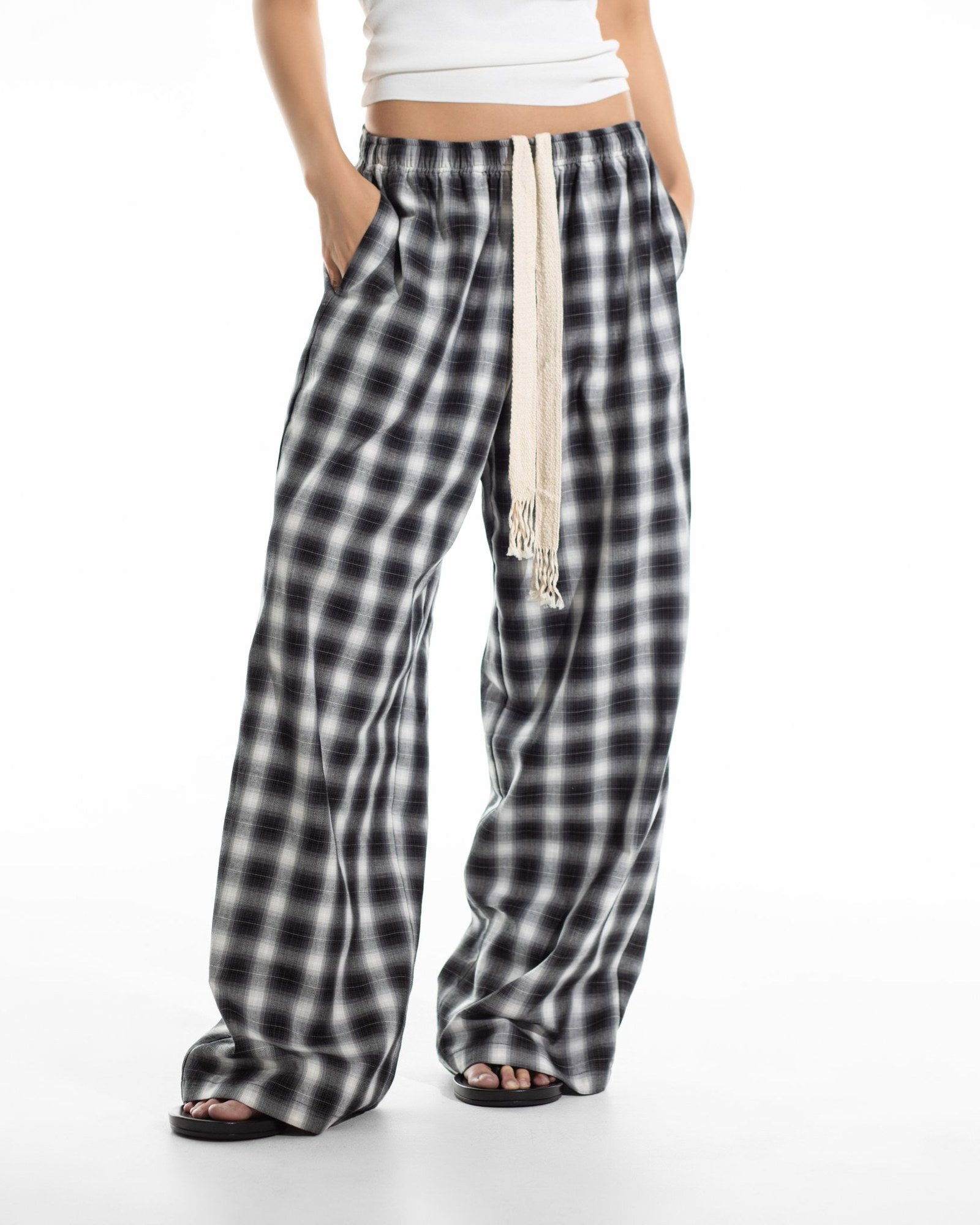 Plaid check wide pants with hands in the side pockets, front view