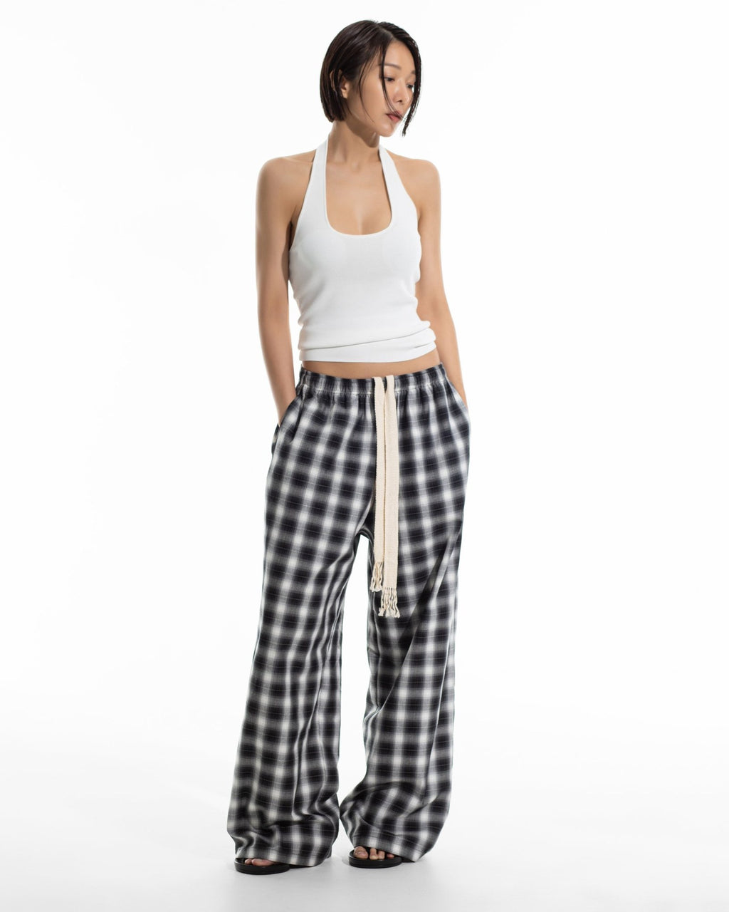 Black plaid check wide pants worn with a white halter top, full length front