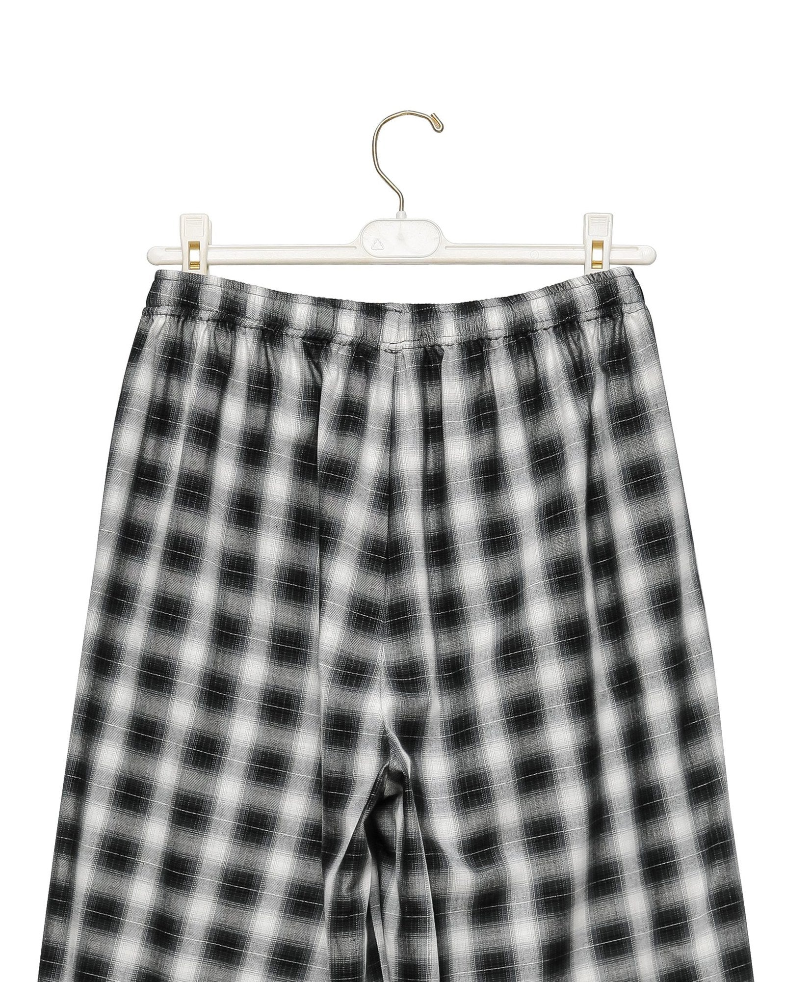 Waistband and drawstring detail of the plaid check wide pants on a hanger